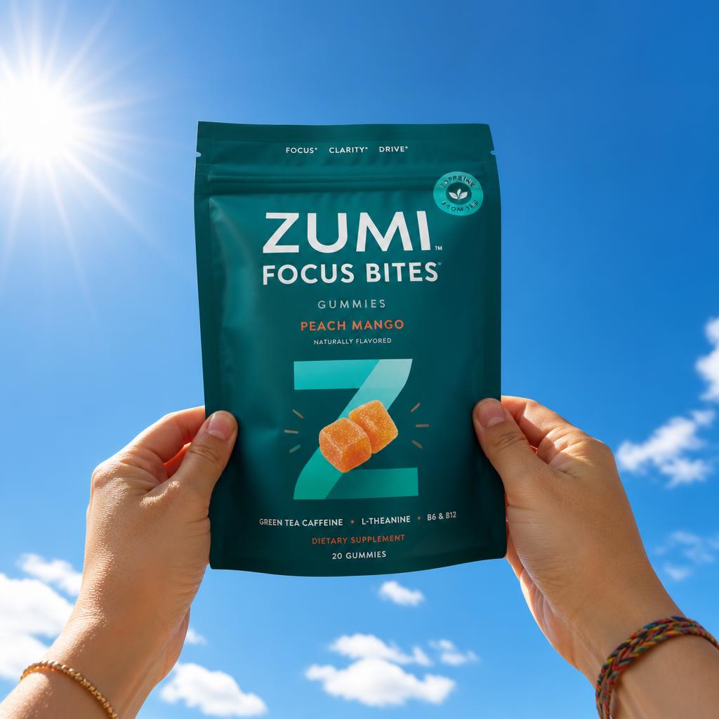 Hands holding the Zumi Focus Bites pouch against a bright sky